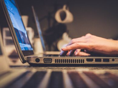 person using silver laptop computer on desk