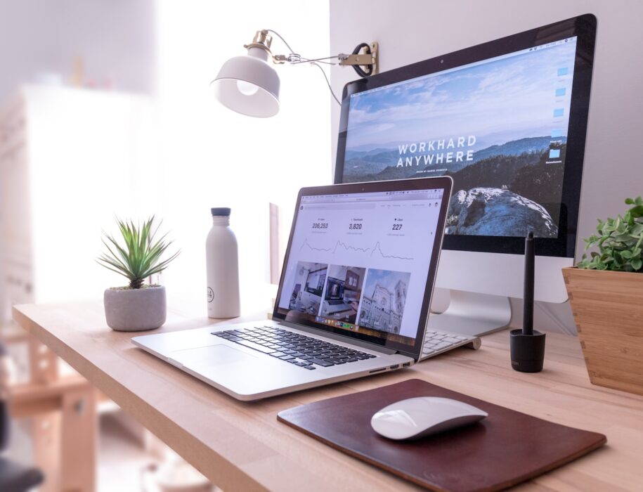 MacBook Pro on table beside white iMac and Magic Mouse